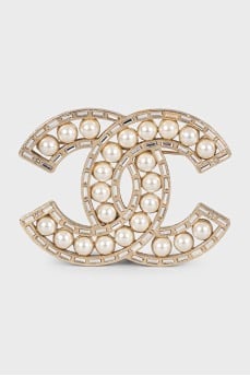 Golden decorated logo brooch