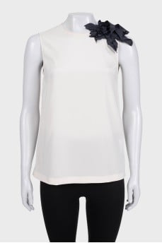 Sleeveless silk blouse decorated with a flower