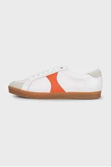 White sneakers with orange inserts and tag