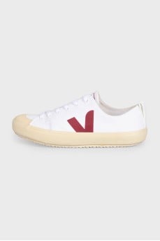 White lace-up sneakers with a red logo