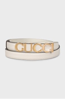 White leather belt with a decorative buckle and tag