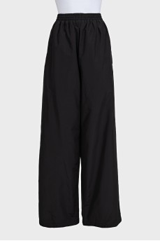 Black wide-leg trousers with elastic waistband and tag