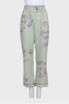 Green silk trousers with a floral print