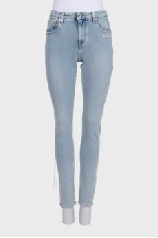 Blue jeans decorated with embroidery and a tag