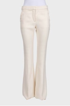 White high-waist flared trousers with creases