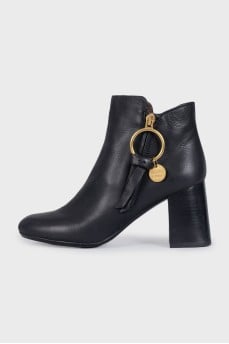 Black leather ankle boots with a gold pendant