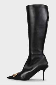 Black leather boots with a gold logo on the toe
