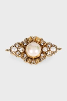 Golden brooch with decor