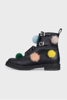 Black leather boots decorated with pom-poms
