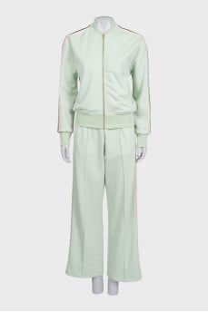 The green tracksuit is decorated with stripes