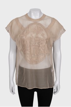 A loose-fitting, transparent blouse decorated with embroidery