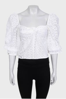 White blouse with puffed sleeves decorated with perforations