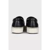 Black leather slip-ons with print