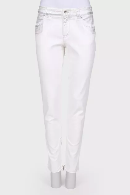 White jeans with a silver coating, with a tag