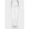 White jeans with a silver coating, with a tag