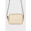 Milk-colored bag with spikes