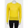 Translucent yellow sweater with a tag