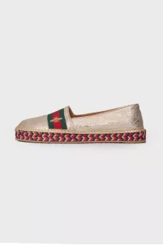 Golden slip-ons with branded appliqué