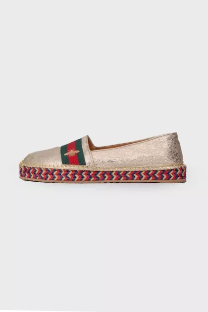 Golden slip-ons with branded appliqué