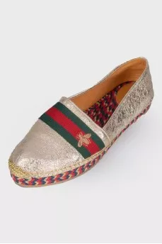 Golden slip-ons with branded appliqué
