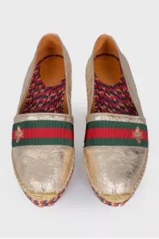 Golden slip-ons with branded appliqué