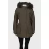 Green parka with fur on the hood with a tag