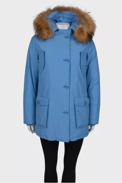 Blue parka with fur on the hood with a tag