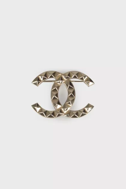 Brooch in the shape of the brand logo