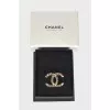 Brooch in the shape of the brand logo