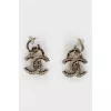 Silver earrings in the shape of the brand's logo