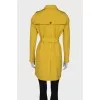 Yellow trench coat at the waist