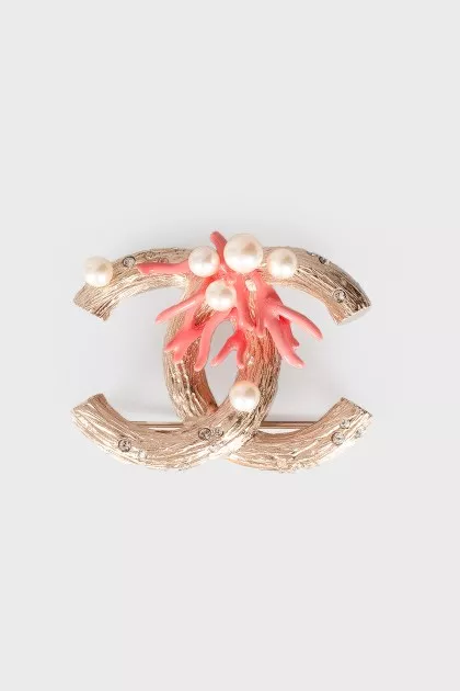 Brooch in the shape of the brand logo
