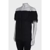 Black top with a frill on the chest