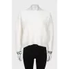White sweater with logo on cuffs