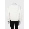 White sweater with logo on cuffs
