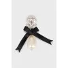 Logo brooch with pearls