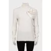 Knitted golf shirt decorated with a flower