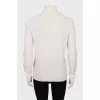 Knitted golf shirt decorated with a flower