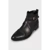 Leather boots decorated with a strap