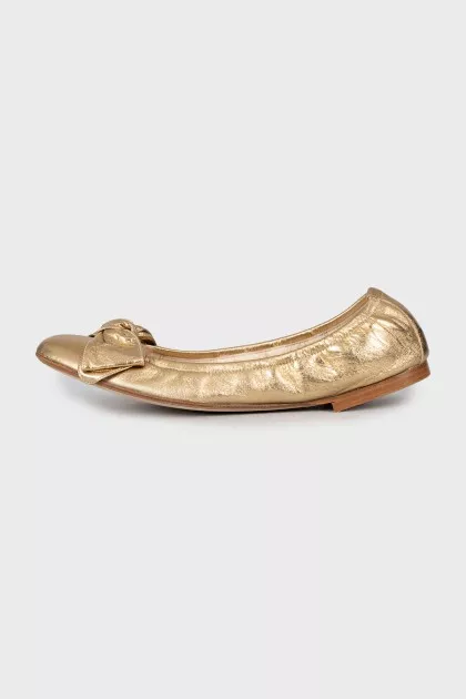 Golden ballet shoes decorated with a bow