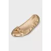 Golden ballet shoes decorated with a bow