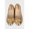 Golden ballet shoes decorated with a bow