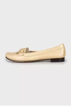 Golden moccasins decorated with a bow