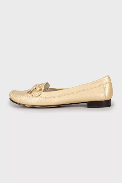 Golden moccasins decorated with a bow