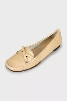 Golden moccasins decorated with a bow