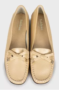 Golden moccasins decorated with a bow