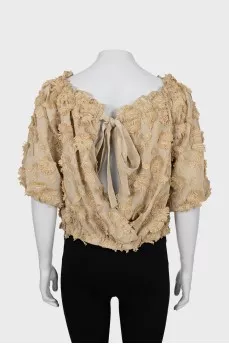Blouse decorated with flowers and frills
