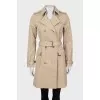 Beige trench coat with gold buttons