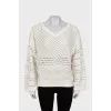 Perforated sweater with voluminous sleeves