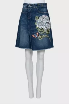 Denim skirt decorated with a patch
